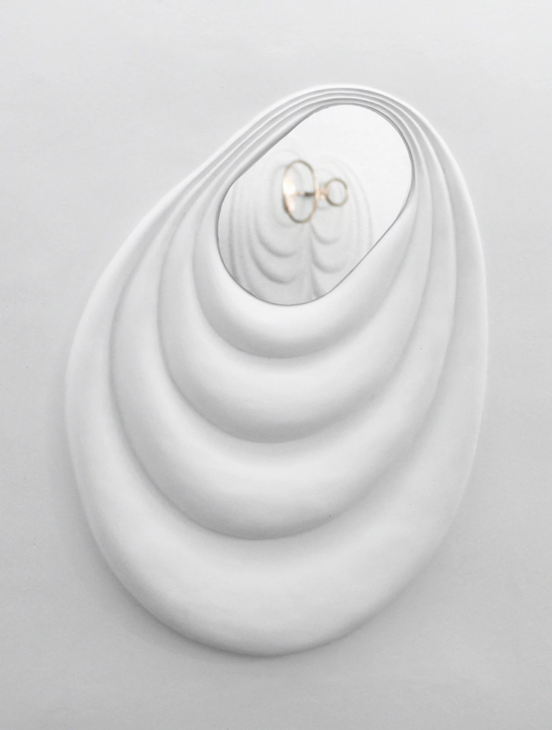 Layered plaster wall sculpture with embedded mirror
