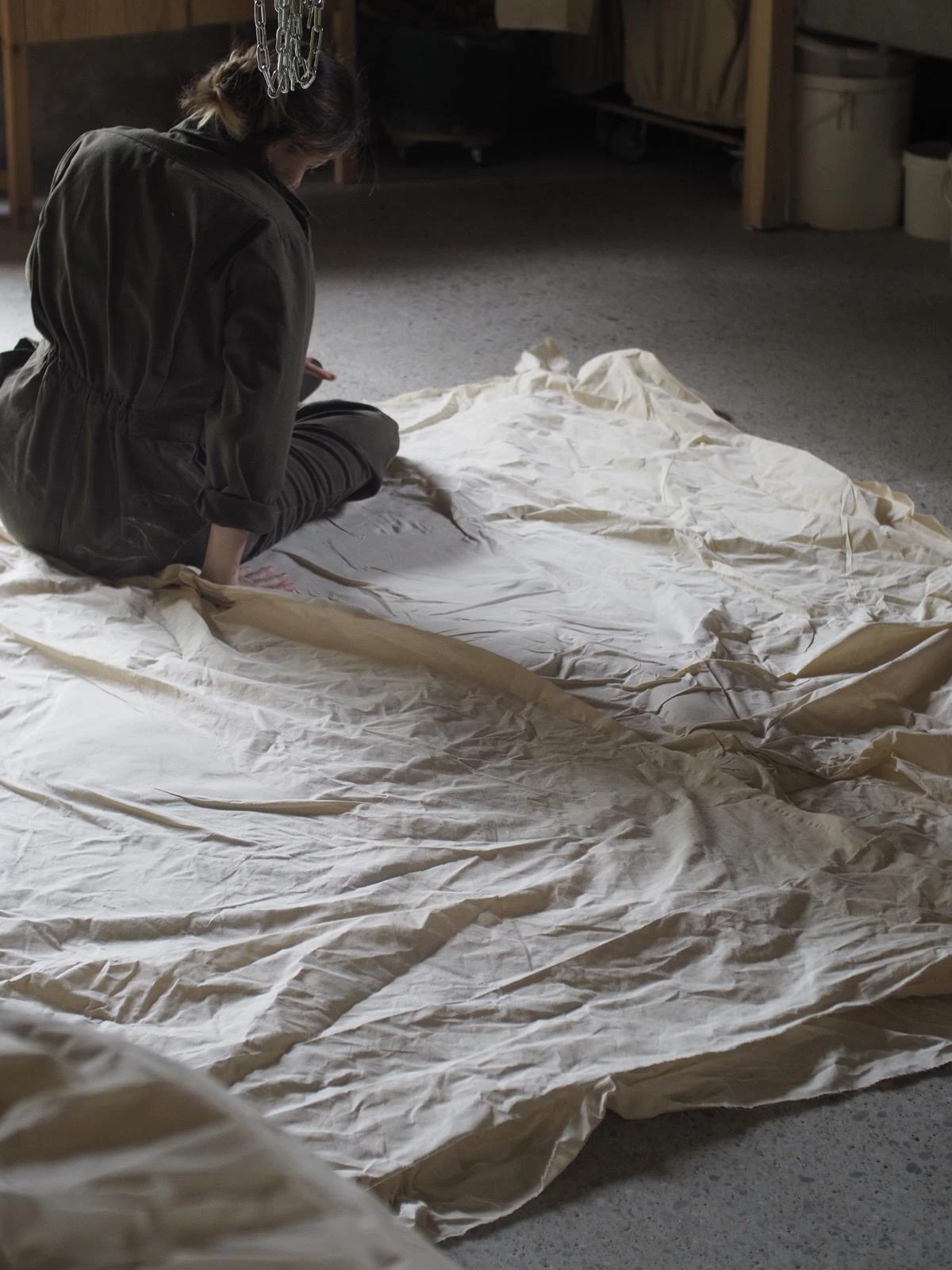 Johanna Meyer working on a large textile spread across the studio floor