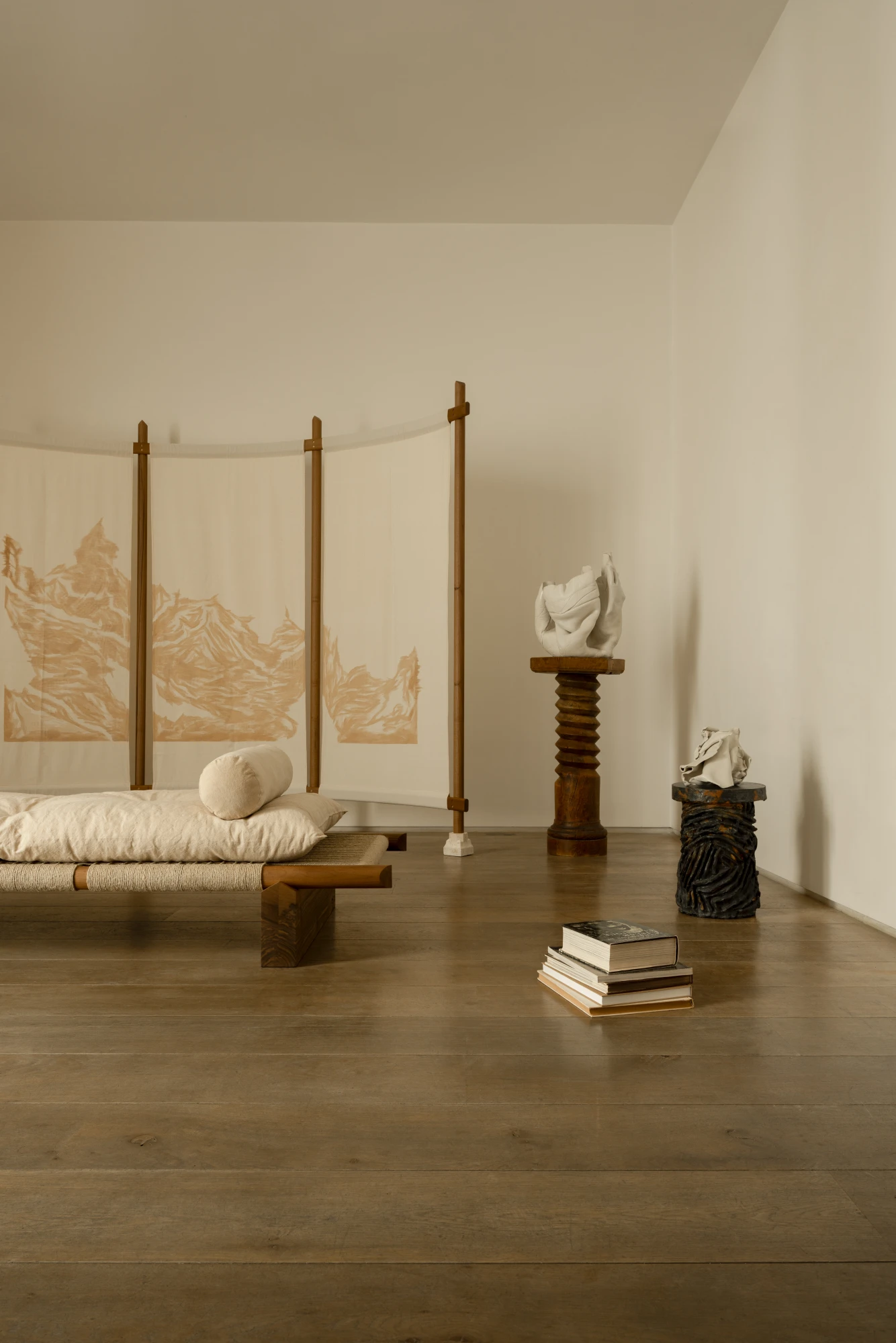 Ceramic pieces on wooden pedestals with textile panels at La Lune Galerie