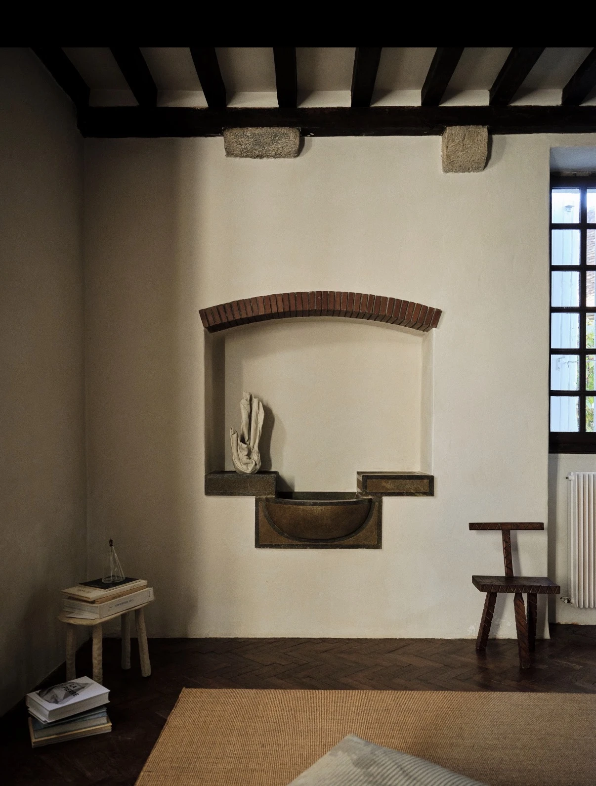 Ceramic piece displayed in an arched niche within an interior room