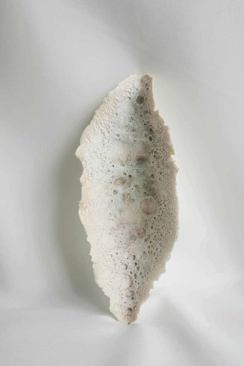 White porous ceramic vessel with organic elongated form