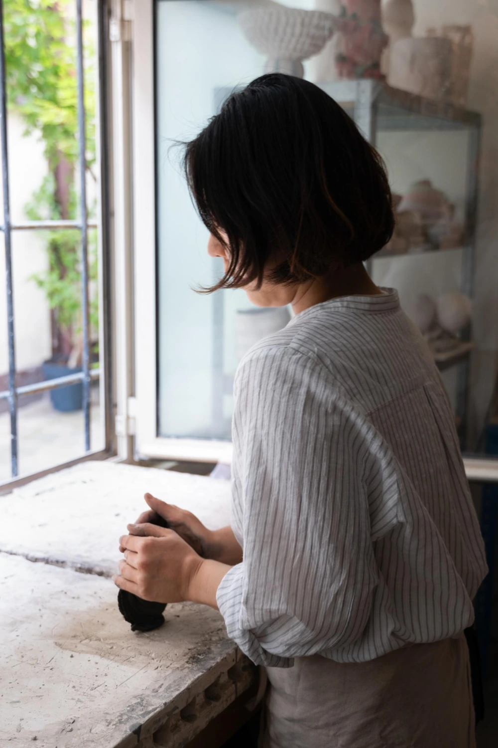 Ceramist working at studio window in Paris