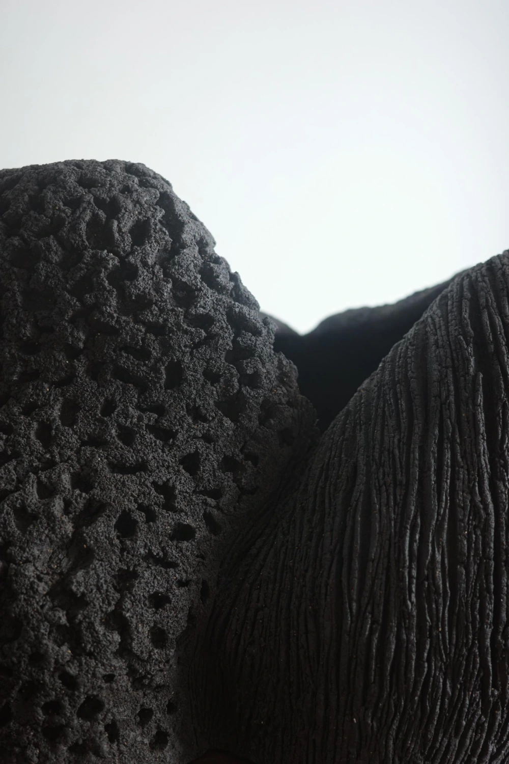 Dark black clay sculptural ceramic with contrasting textures