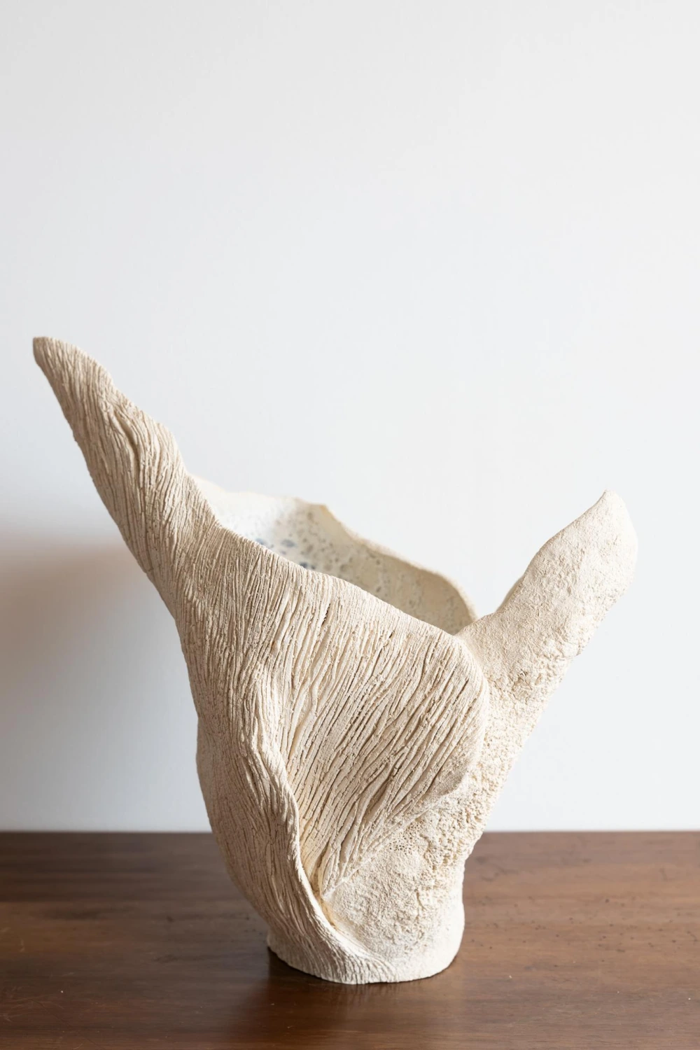 White sculptural ceramic vessel with organic wing-like form